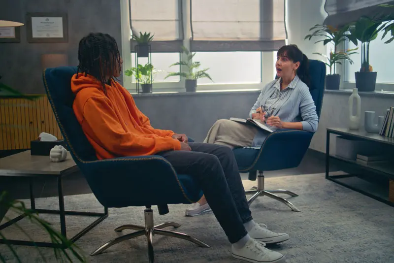 Teen talks to therapist in a partial hospitalization program