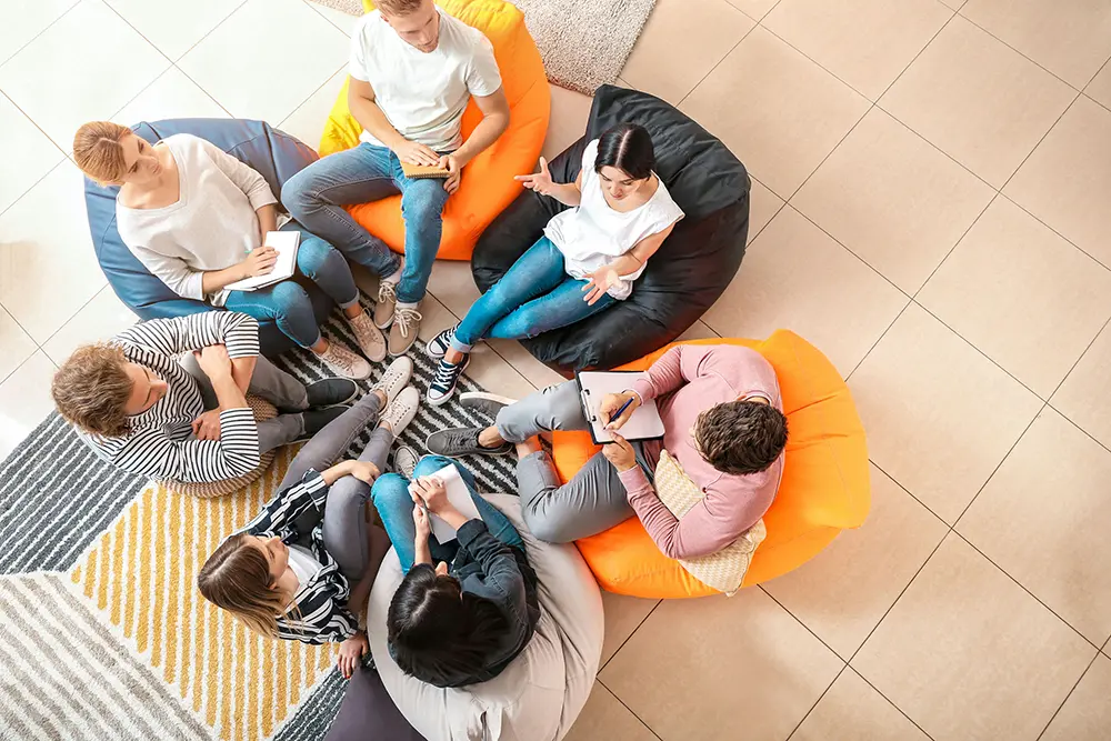 Teen participating in dual diagnosis therapy for OCD and addiction alongside peers and a trained clinician.