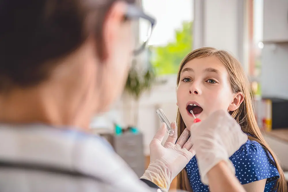 Doctor evaluating a child for PANDAS disorder with input from parents during a medical consultation.