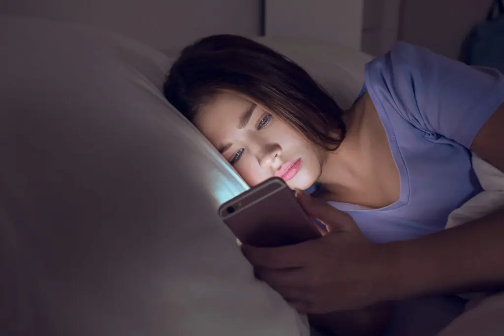 Teen scrolling social media late at night where drug trends often spread