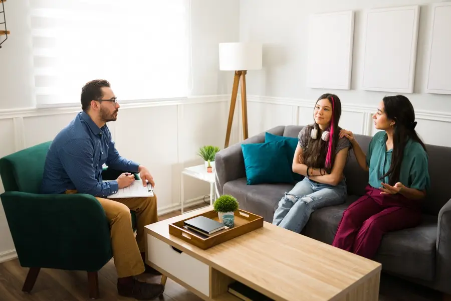 Teen and parent meeting with a mental health professional to discuss treatment options
