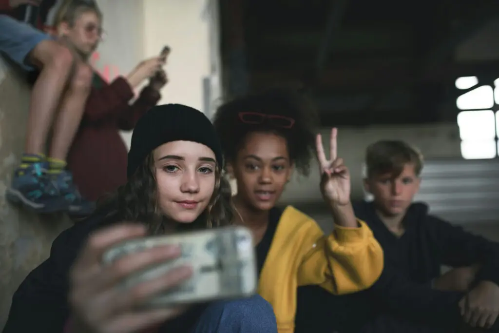 Two teenage girls with ADHD posing while filming with a smartphone.