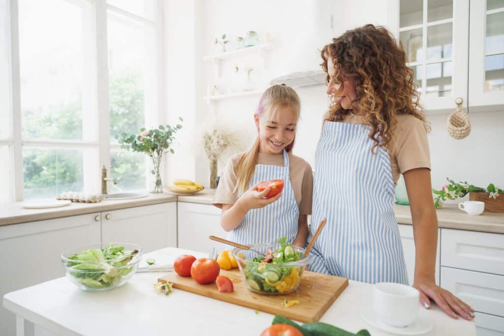 mom cooking with her daughter and enjoying the mental health benefits of cooking with her kids