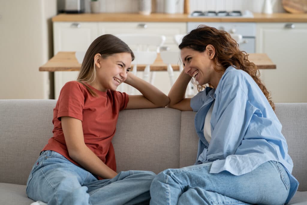 mom and daughter laughing on couch after mom has helped with cope with her panic attacks