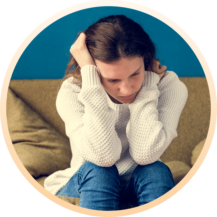 stressed female teenager sitting of sofa with PTSD
