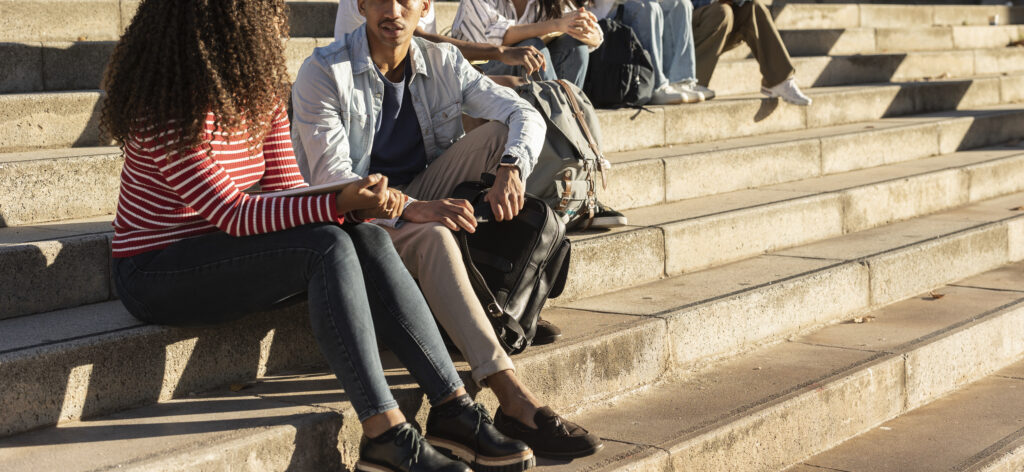 group of teens sitting on stairs talking