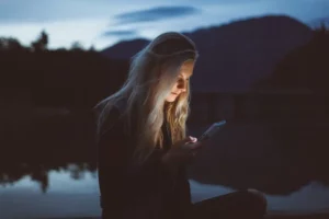 teen female on her phone at night thinking about teen electronic addiction