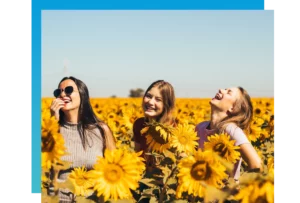 a trio of teen girls in a sunflower field as part of group therapy for adolescents