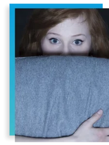 teen girl hiding behind pillow in anxiety treatment for adolescents