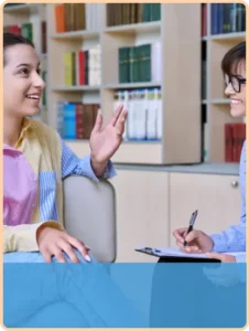 teen girl gestures with her hand as therapist looks on