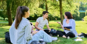 teen girl and boy speaking to therapist in an outdoor setting