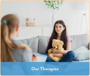 teen girl holding stuffed animal and listening to a therapist