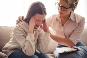 adolescent girl painfully discussing something with a therapist