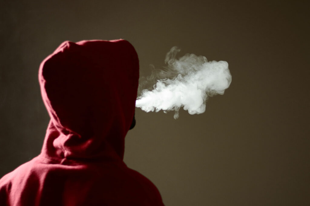 a teen puffs smoke to show why do teens use marijuana