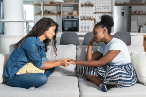a mom holds a teen's hand to show how to help a teen with anxiety