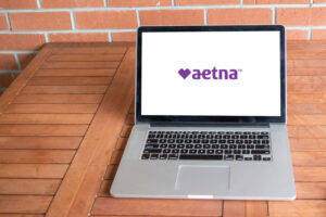 a computer showing an aetna logo with a heart and the name to show aetna mental health coverage