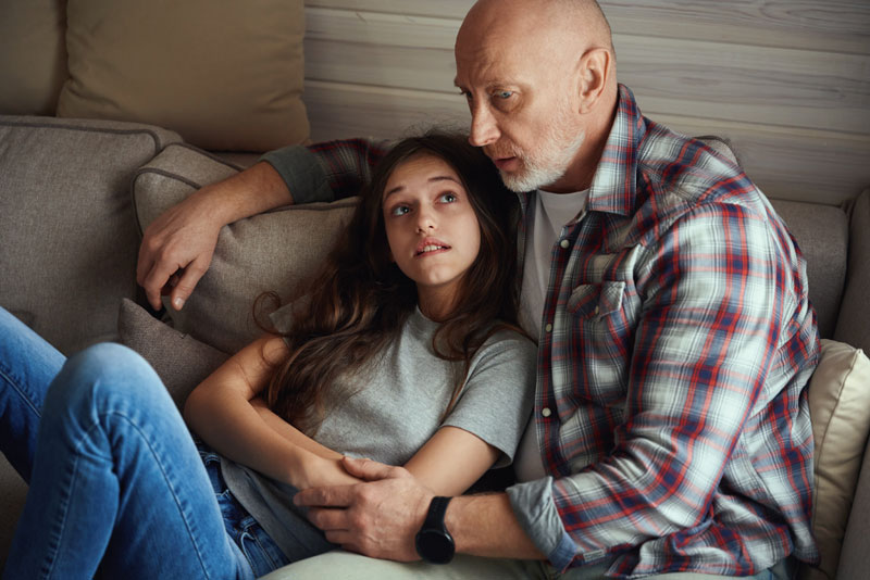 a teen leans against their parent as they talk about a bipolar disorder test for teens