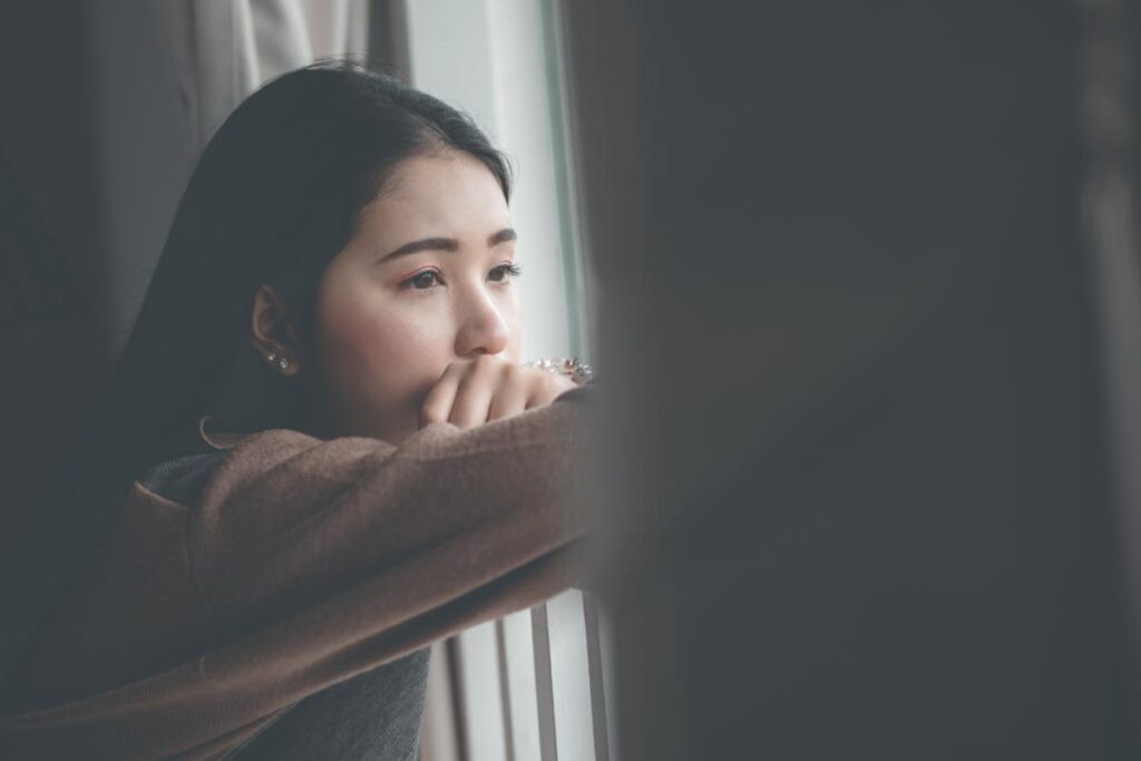 Girl looks out window as she considers teen anxiety treatment in South Shore MA