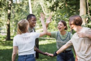 Group of teens play outside while enjoying mental health activities for teens