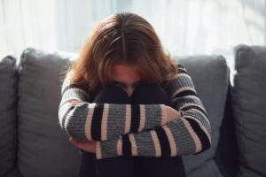 Girl sits on couch after starting medication for bipolar disorder