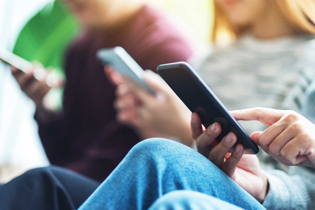 Teens on their phones to symbolize harmful effects of social media on teens