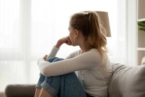 Teen sits on couch and fights recurring thoughts of self-harm