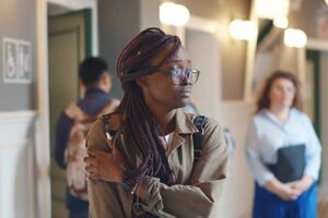 Teen holds shoulder and walks hall, thinking about attachment disorder in teens 
