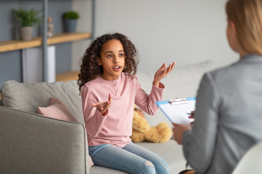 Therapist providing dual diagnosis care for a teen with PTSD and addiction in a supportive setting