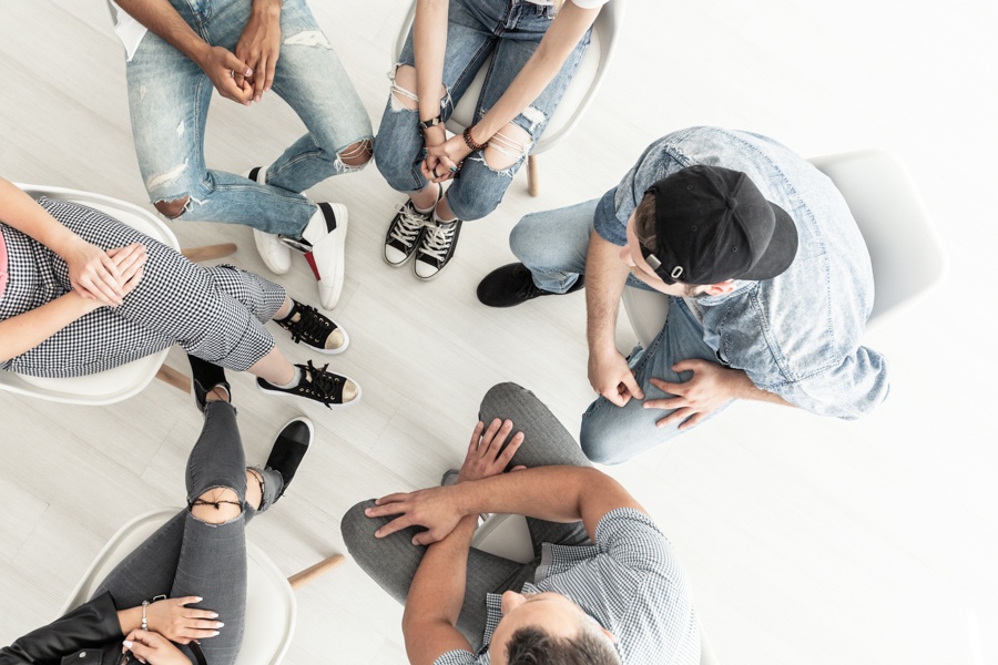Group of teens in therapy session with a facilitator, showing support through intensive outpatient treatment