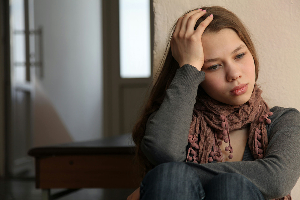 Teen struggling with emotional distress from PTSD and substance use, showing signs of isolation and trauma
