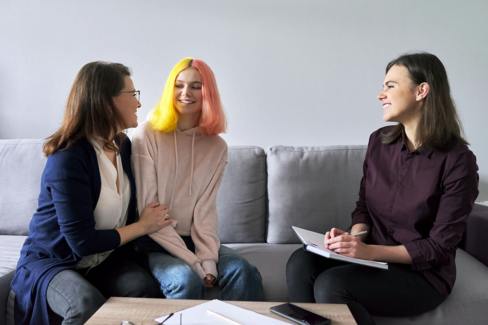 Parent and teenager meeting with a mental health therapist for an initial consultation.