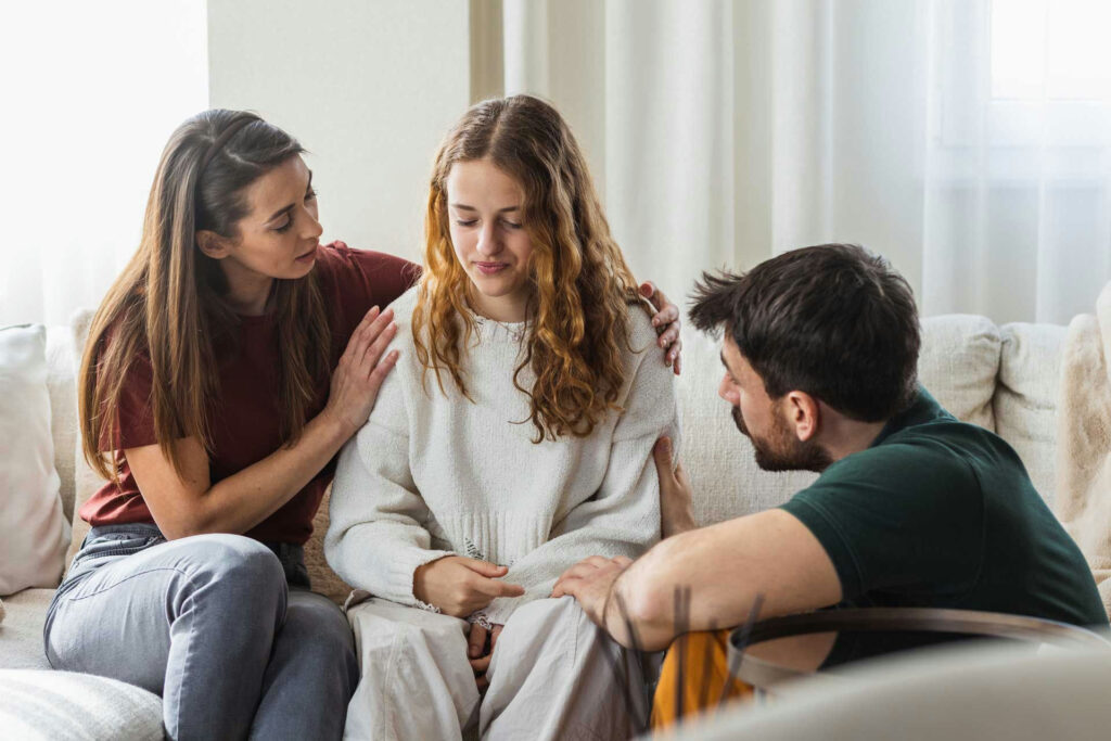 Teen speaking openly while parents listen without judgment