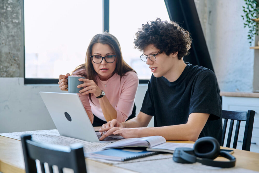 helicopter parent closely monitoring teen doing homework at home