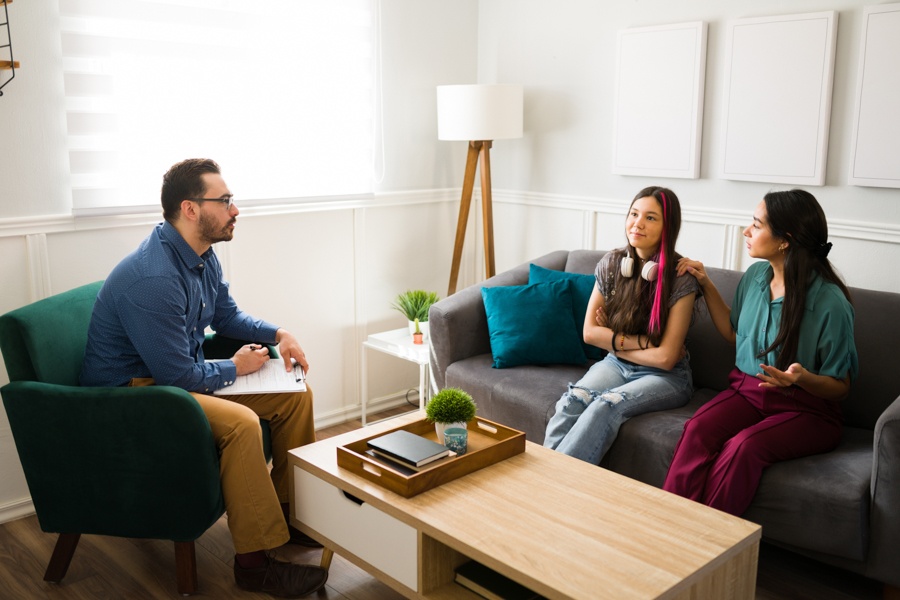 Teen and parent meeting with a mental health professional to discuss treatment options