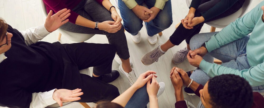 Teenagers participating in specialized mental health treatment with a counselor in a supportive therapeutic setting.